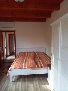 BárdudvarnokVendégház Petörke的铺有木地板的客房内的一张白色床