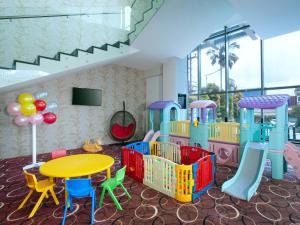 巴厘巴板Platinum Hotel & Convention Hall Balikpapan的客房设有带桌椅的游乐场。