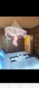 东德岛Riverside Bungalow Don Det的床上有粉红色泰迪熊