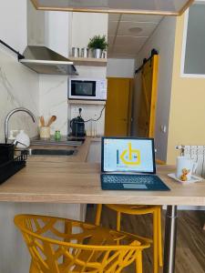 贝纳斯克Work Room - kasasbenas的厨房里的一台笔记本电脑坐在木桌旁