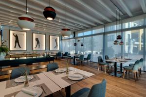 科斯塔巴伦娜巴瑟罗鲸鱼海岸高尔夫水疗酒店的餐厅设有桌椅和大窗户。
