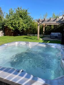 伯恩茅斯Modern, central bungalow with Luxury Hot tub的后院的热水浴池,带凉棚