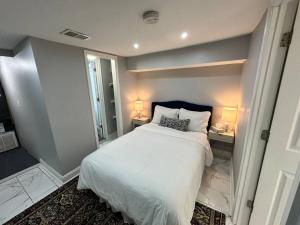 华盛顿Downtown Delight in Heart of DC’s Bustling Streets的卧室配有白色的床和带两盏灯的书桌。