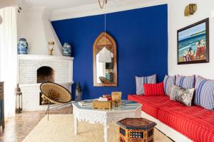 丹吉尔Lalla Soulika的客厅设有红色的沙发和蓝色的墙壁