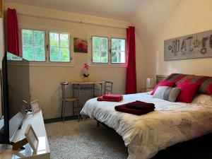 圣马塞尔Le Bois des Sources的一间卧室配有一张带红色枕头的大床
