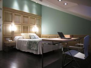 布尔戈斯哥特之路酒店的一间卧室配有一张床和一张带笔记本电脑的书桌