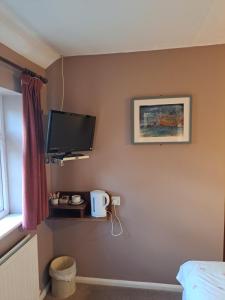 亨廷登The Prince of Wales的卧室配有壁挂式平面电视。