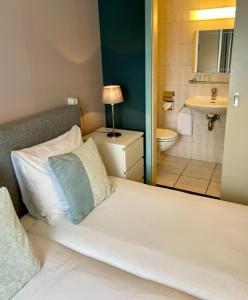 法尔肯堡Hotel De la Ruïne的一间带白色床的卧室和一间浴室