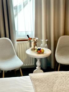 法尔肯堡Hotel De la Ruïne的一张桌子,上面放着一碗水果,上面放着两把椅子