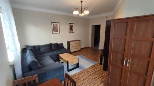 弗沃茨瓦韦克Apartament Warszawska的客厅配有蓝色的沙发和桌子