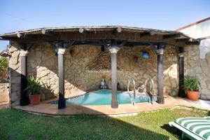 奇克拉纳－德拉弗龙特拉Villa Indie的一座石头建筑中的游泳池,设有凉亭