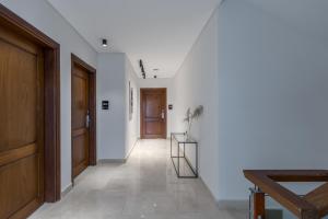 开罗Livingville Nine的一条带白色墙壁和木门的走廊