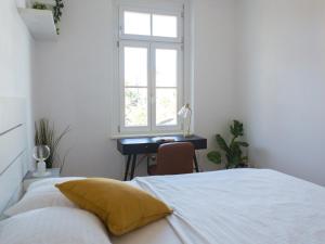 格拉茨Pleasant City Apartment的一间卧室配有一张床和一张带窗户的书桌