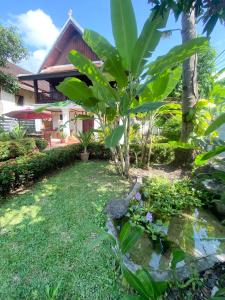琅勃拉邦Luang Prabang Residence & Travel的房屋前的花园