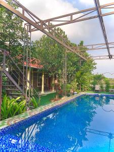 Vũ LâmTAM COC SUNRISE HOMESTAY (VÂN VIỄN, đội 2)的一座大型蓝色游泳池,位于房子旁边
