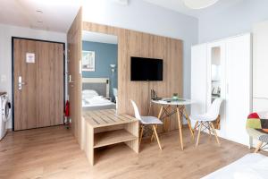 华沙RentPlanet - Apartamenty Wolska的配有一张床和一张桌子及椅子的房间