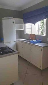 逊邱伦36 Petrel Road的厨房配有白色冰箱和水槽