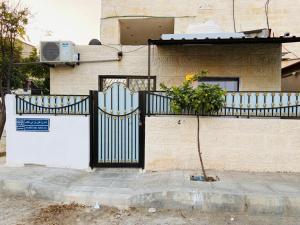 杰拉什Jerash sky1的一座有黑色门和植物的房子
