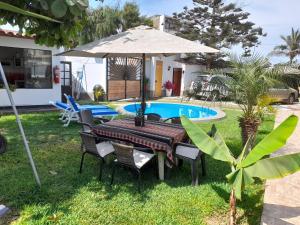 万查科Montemar Apart Hotel - Playa Huanchaco的一张桌子,旁边是一把遮阳伞