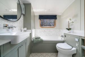 伦敦Luxurious houseboat near Canary Wharf in London的一间带水槽、浴缸和卫生间的浴室