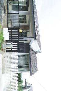 关丹Cozy, Spacious, Air Cond UMP Gambang Homestay -- The Pigeon Guest House的享有带黑白色楼梯的建筑的外部景色