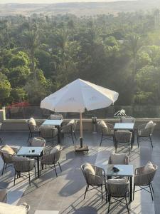 开罗Golden Pyramids Sunrise Hotel的一个带桌椅和遮阳伞的庭院
