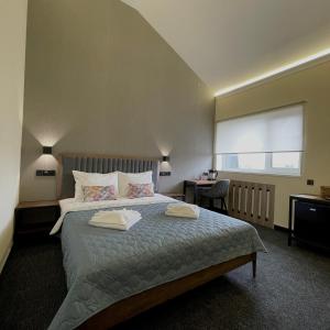 基辅尼维克酒店的一间卧室设有一张大床和一个窗户。
