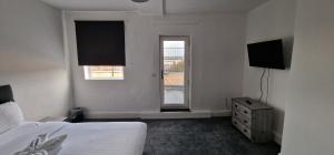 巴恩斯利APARTMENT IN CENTRAL BARNSLEY的一间卧室配有一张床、一台电视和一个窗口