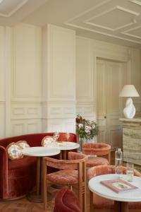 塞纳河畔讷伊Le 5 Particulier的客厅配有两张桌子和一张红色沙发