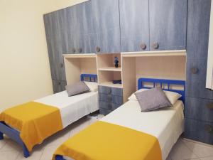 墨西拿IL POSTO GIUSTO的蓝色和黄色的客房内的两张床