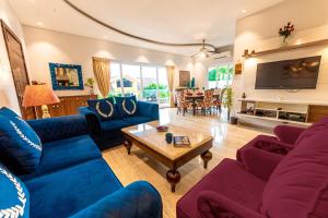 巴加Infinity Villa, 5BHK-Private Pool-Caretaker, Baga的客厅配有蓝色的沙发和桌子