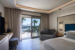 科林比亚Atlantica Aegean Blue的酒店客房设有床、沙发和阳台。