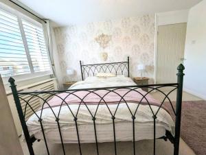 KeyworthSpacious lovely 3 Bed House in Keyworth Nottingham suit CONTRACTORS OR FAMILY的一间卧室配有一张黑色床和粉色毯子