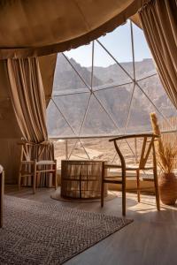 艾恩Pura Eco Retreat, Jebel Hafit Desert Park的客房设有带桌椅的大窗户。