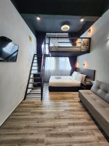 乔治市Georgetown Inn by Sky Hive的一间卧室设有一张床,楼梯位于卧室内