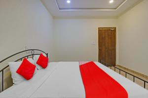 瓦朗加尔OYO Flagship Hotel Vathsalya的一间卧室配有红色枕头的床