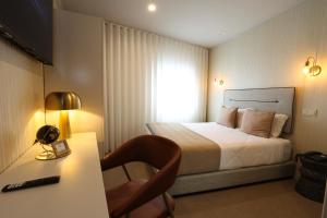 波尔图美洲酒店的酒店客房配有一张床和一张带台灯的书桌