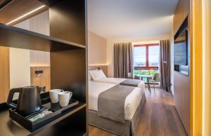 潘普洛纳Occidental Pamplona的酒店客房带一张床,还有一间景观房