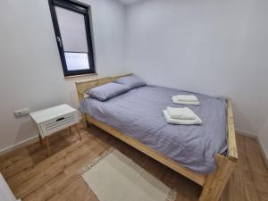 代日La Casuță的一间卧室配有一张床,上面有两条毛巾
