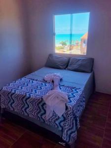 马拉戈日casa temporada maragogi的一间卧室设有一张床和一个海景窗户
