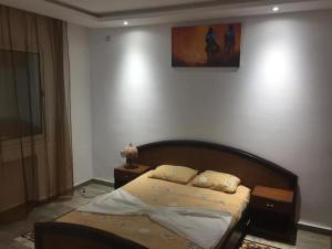 Chott Meriemgrand S+1 avec vaste terrasse panoramique的卧室配有一张床,墙上挂着一幅画