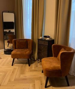 蒙斯Le Vieux Cèdre Grand Place的更衣室配有两把椅子和镜子
