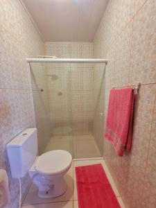 马拉戈日casa temporada maragogi的带淋浴、卫生间和红色毛巾的浴室