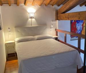 利沃诺TUSCANY LOFT IN THE CITY的一间带一张床的卧室,位于带木制天花板的房间内
