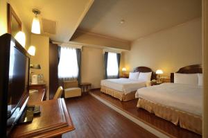 高雄歌德商旅的酒店客房设有两张床和一台平面电视。