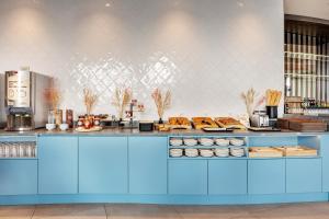 里尔B&B HOTEL Lille Lillenium Eurasanté的厨房配有蓝色的柜台,上面有食物