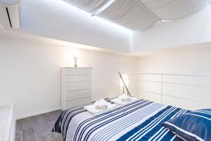 都灵Exclusive Loft Crocetta - Free Private Parking & Wi-Fi - 5 min To Metro Nizza的白色卧室配有蓝色和白色条纹床