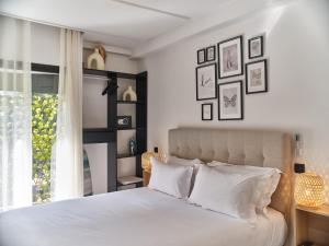 卡萨布兰卡TheCasaEdition Gauthier Residency City Center的卧室配有带白色枕头的床和窗户。