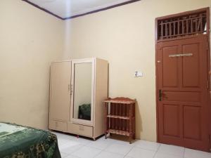 TabingPenginapan Syari'ah Parak Anau的卧室配有一张床,门旁设有镜子