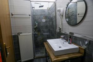 沃斯科波亚Vila Falo的浴室配有盥洗盆和带镜子的淋浴